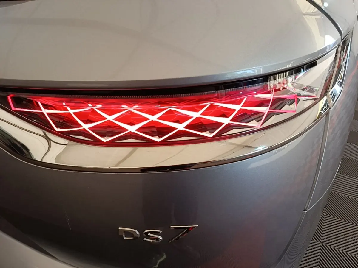 Gros plan sur le feu arrière droit rouge à motif géométrique du DS7 Crossback gris foncé.