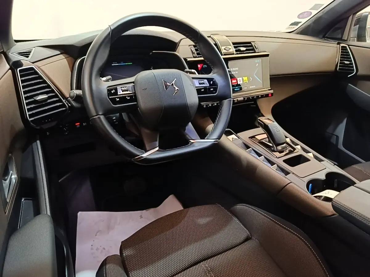 Vue intérieure côté conducteur du DS7 Crossback E-TENSE 225 Business 2021, volant cuir noir et écran tactile central.