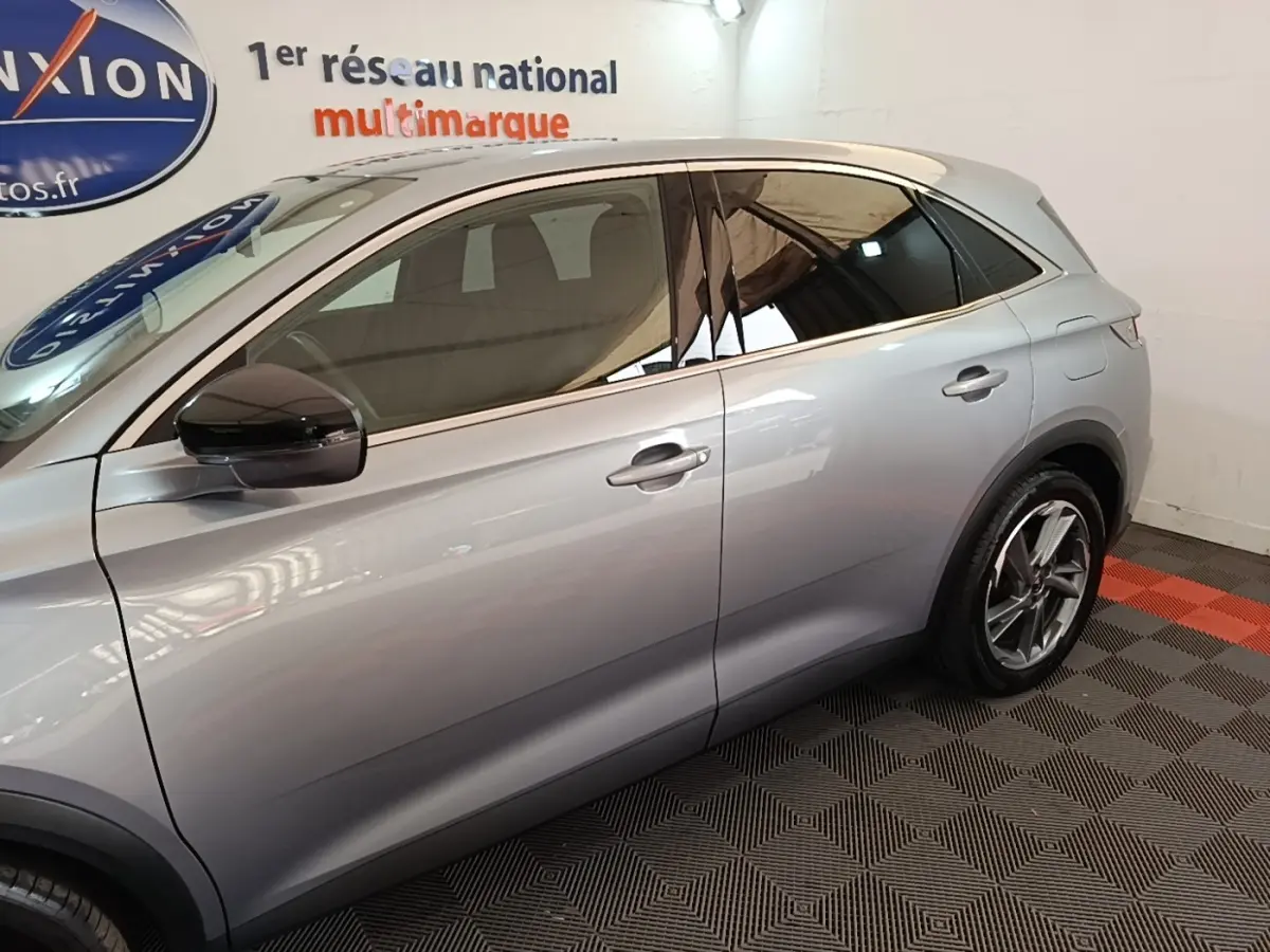 Profil côté gauche d'un DS7 Crossback E-TENSE 225 Business gris foncé avec jantes alliage et vitres teintées.