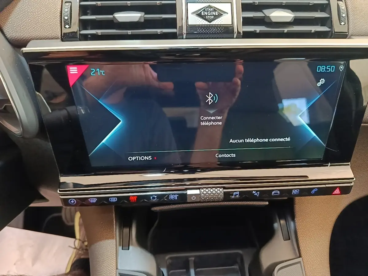 Vue rapprochée de l'écran tactile central et des commandes du tableau de bord du DS7 Crossback E-TENSE gris foncé.