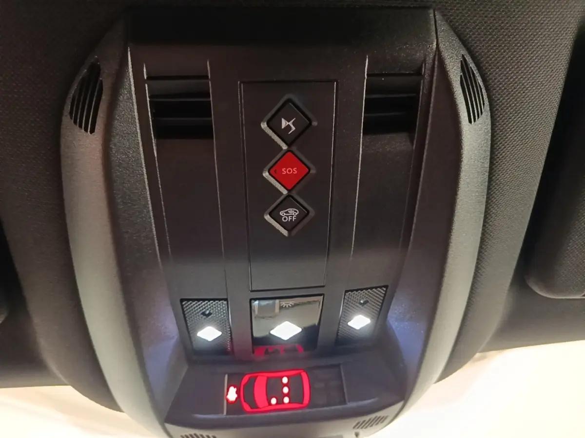 Gros plan sur la console de toit intérieure du DS7 Crossback E-TENSE 225, avec boutons SOS et éclairage LED allumé.