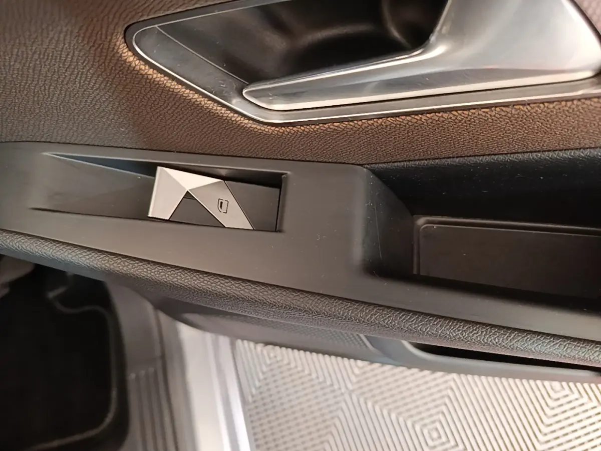Détail de la poignée intérieure et commande de vitre côté conducteur du DS7 Crossback gris foncé, finition cuir.