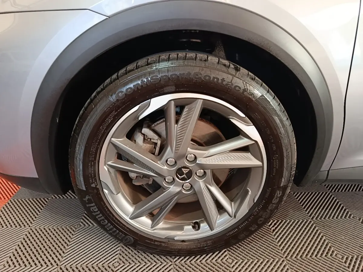 Gros plan sur la roue avant gauche gris foncé du DS7 Crossback E-TENSE 225 BUSINESS avec jante alliage distinctive.