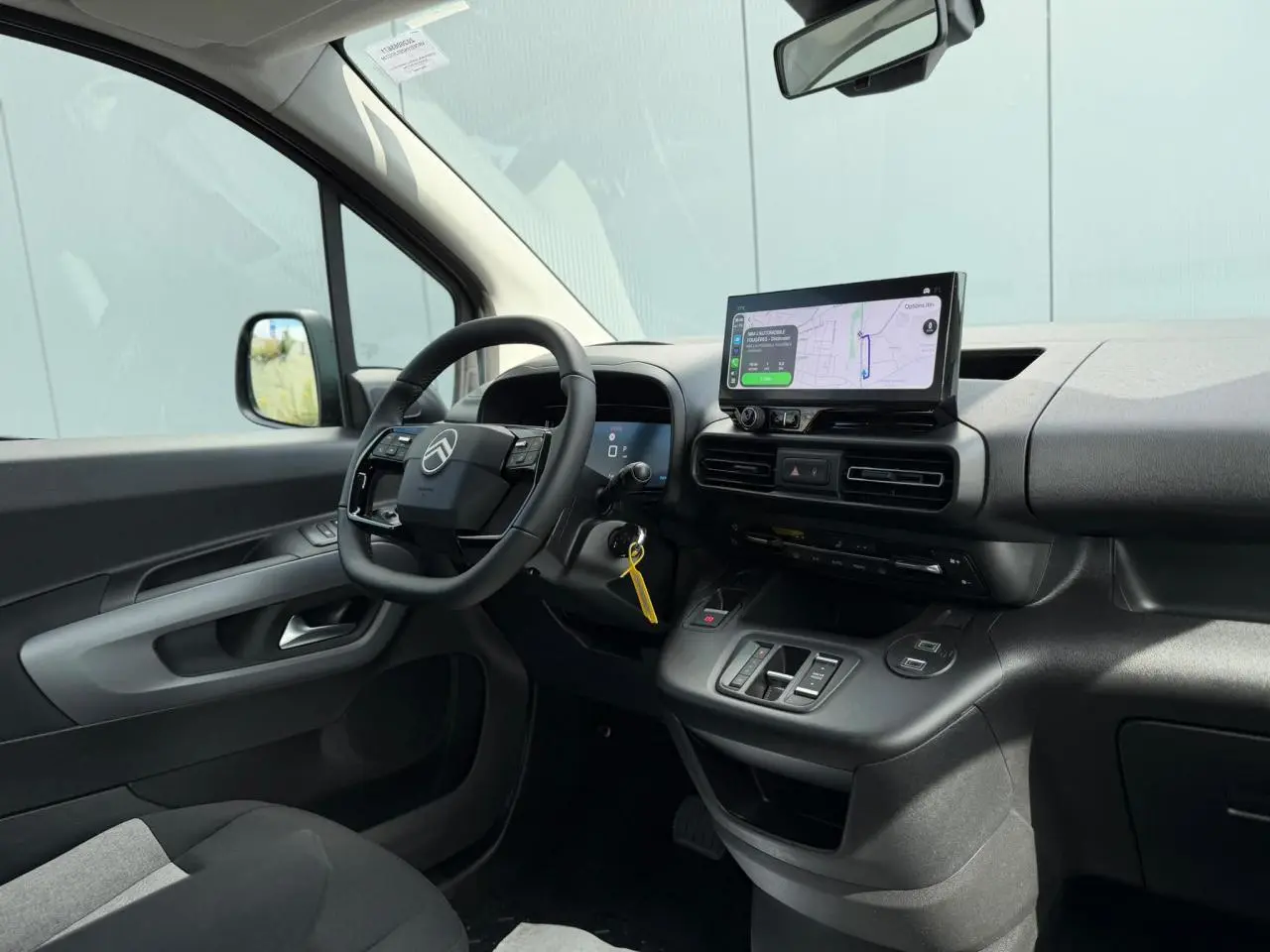 Intérieur du Citroën Berlingo Multispace 2026 vu côté conducteur, tableau de bord noir avec écran tactile central.