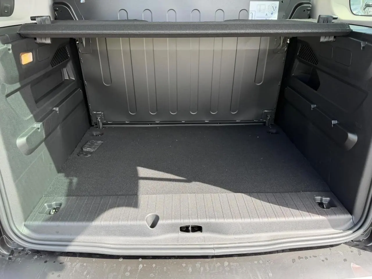 Vue intérieure du coffre spacieux du Citroën Berlingo Multispace 2026, avec tapis noir et habillage gris foncé.