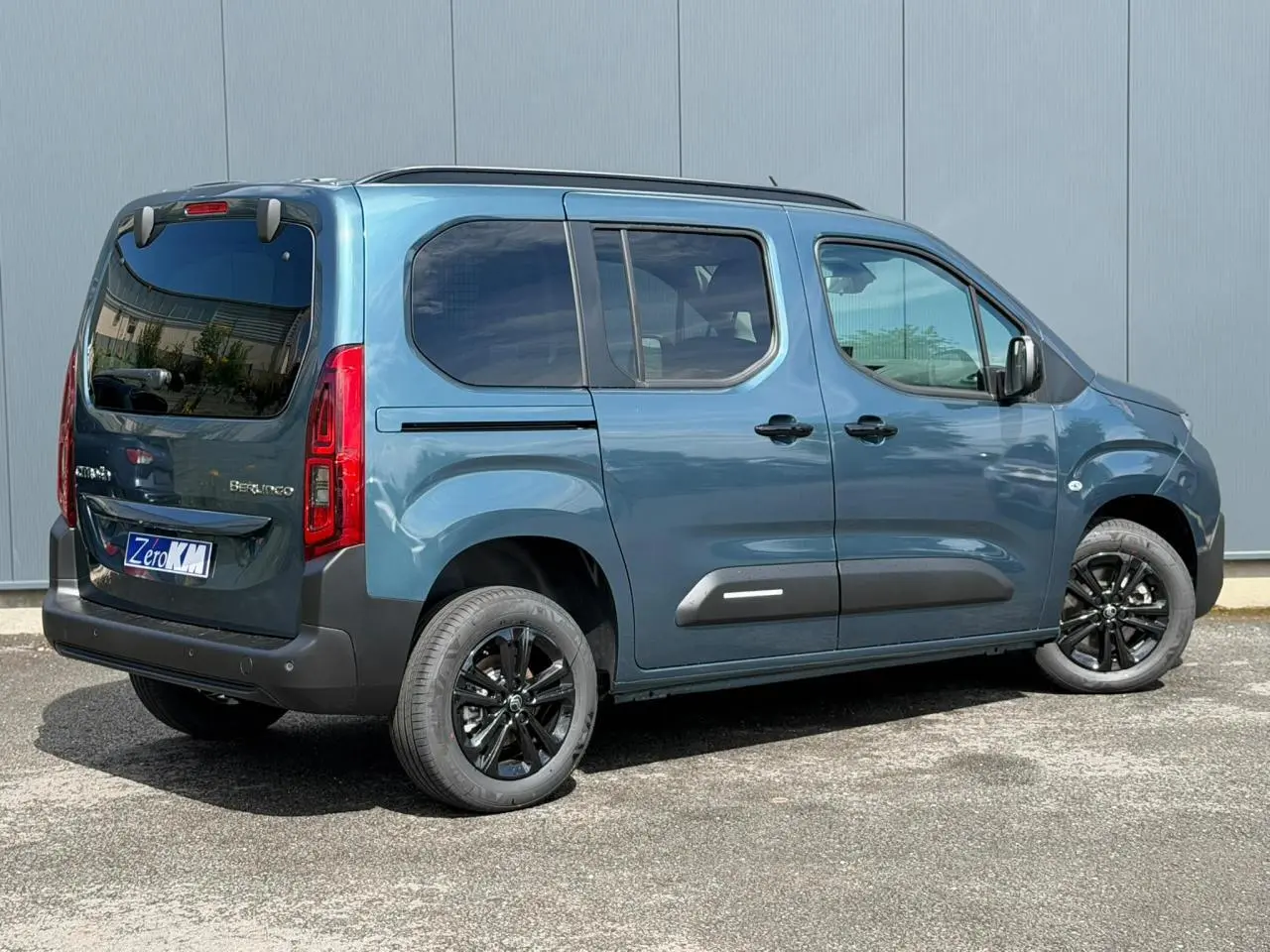 Vue 3/4 arrière droite du Citroën Berlingo Multispace bleu Kiama avec jantes alliage noires et lunette arrière ouvrante.