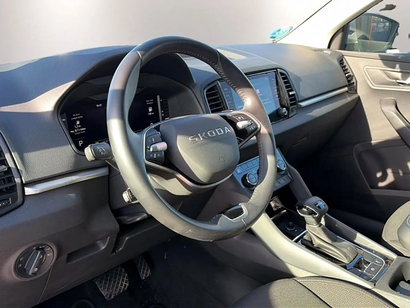 Intérieur de Skoda Karoq gris 2025, vue côté conducteur sur volant multifonction et console centrale avec boîte auto.