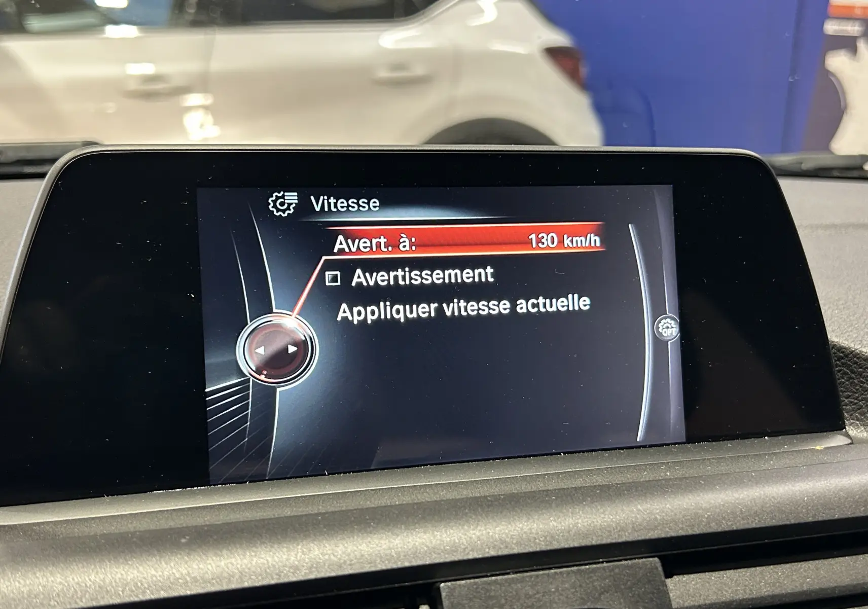 Écran central de BMW Série 1 116d Business 2015 montrant le réglage d’avertissement de vitesse à 130 km/h.