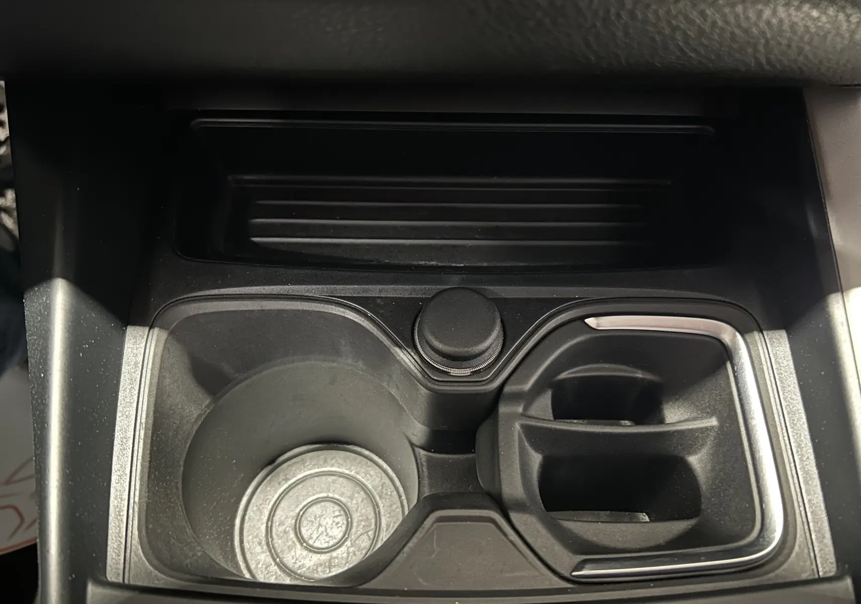 Gros plan sur le porte-gobelets central noir de la BMW Série 1 116d Business 5 portes de 2015.