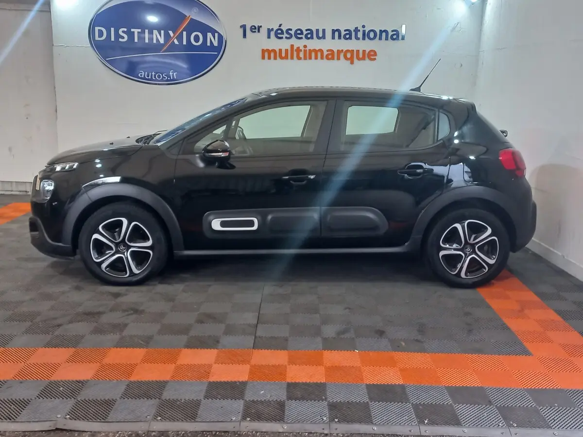 Profil droit d'une Citroën C3 noire 2024 avec protections latérales distinctives et jantes stylisées en concession.