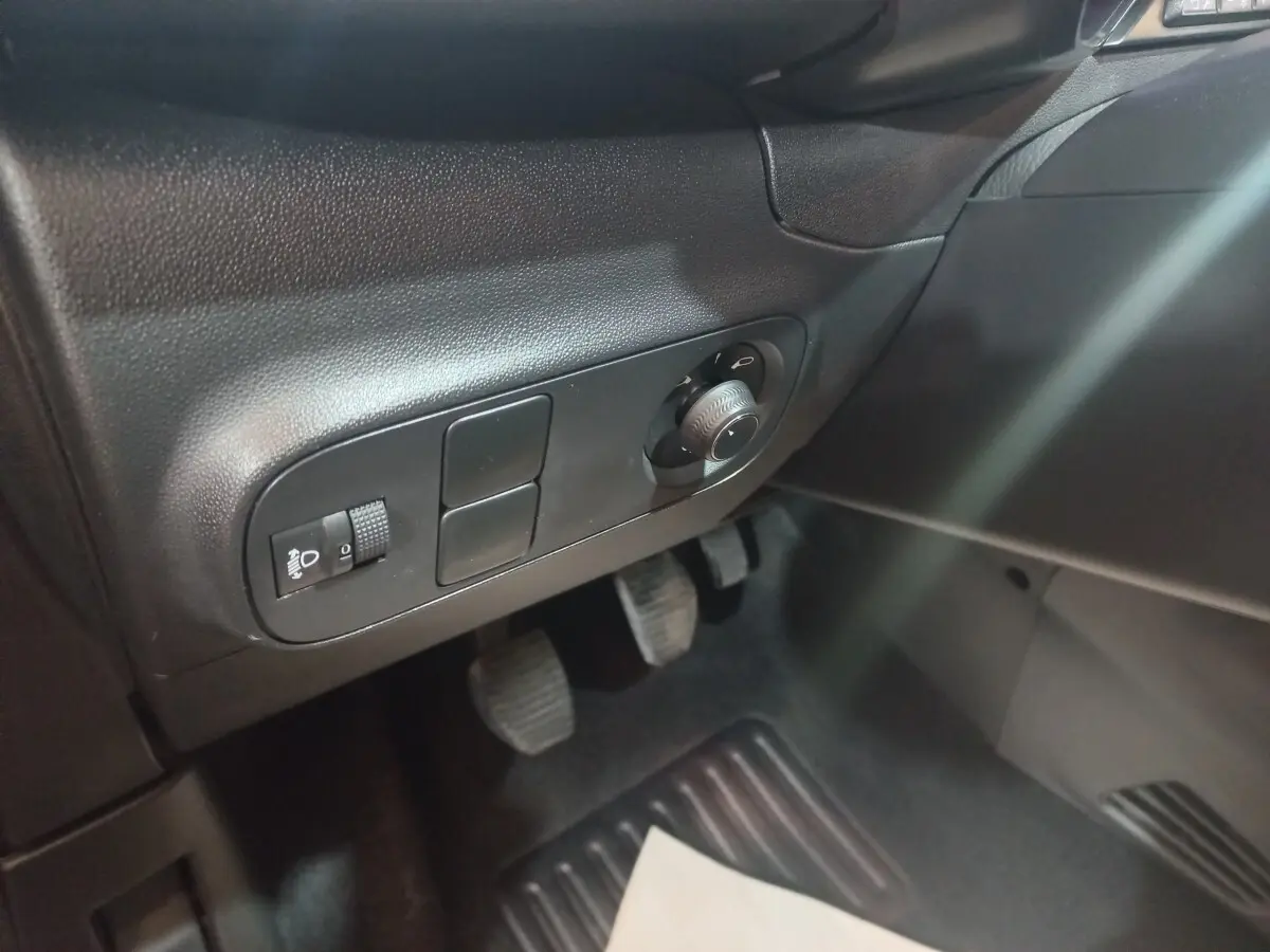 Vue intérieure côté conducteur de la Citroën C3 2024 noire, montrant les commandes d'éclairage et les pédales.