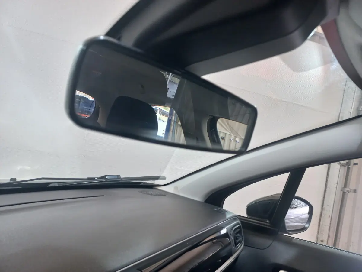 Vue intérieure du tableau de bord et rétroviseur central d'une Citroën C3 noire, angle côté passager.