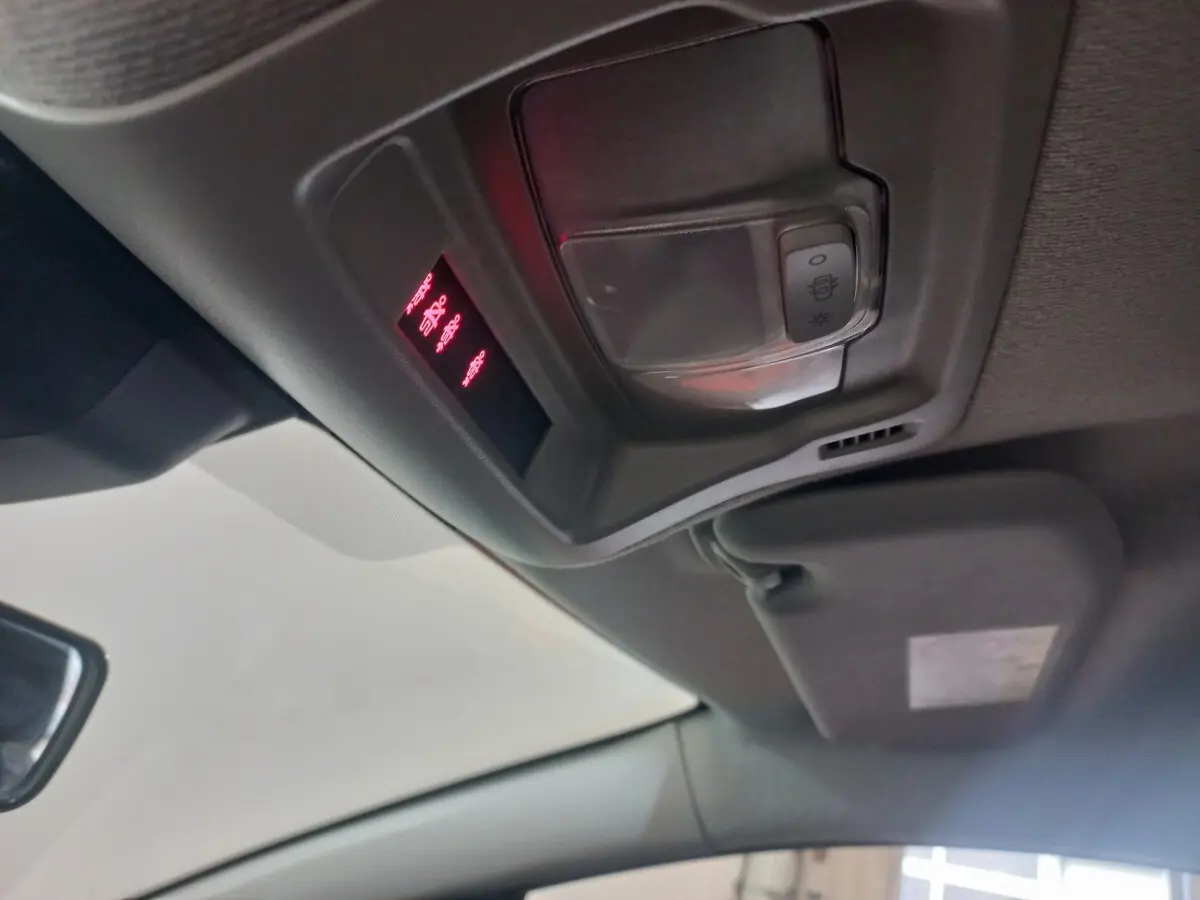 Vue intérieure du plafond avant de la Citroën C3 noire 2024, montrant la console de plafonnier avec éclairage rouge et commandes.