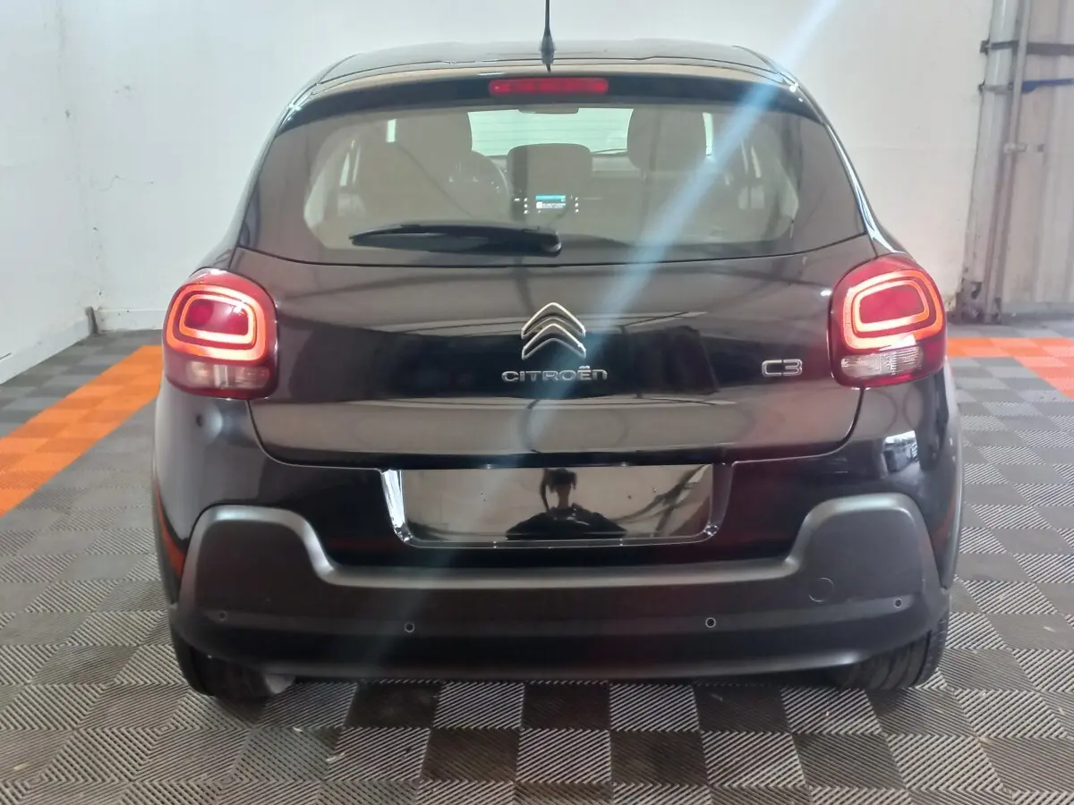 Vue arrière d'une Citroën C3 noire 2024 avec feux arrière LED allumés dans un garage.