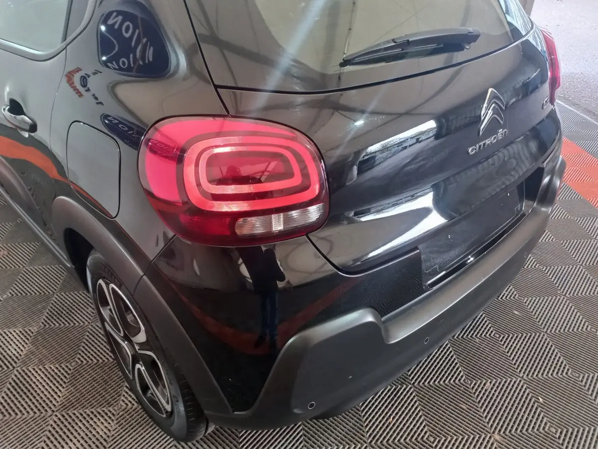 Vue 3/4 arrière droite d'une Citroën C3 noire 2024 avec feux arrière LED et jantes au design moderne.