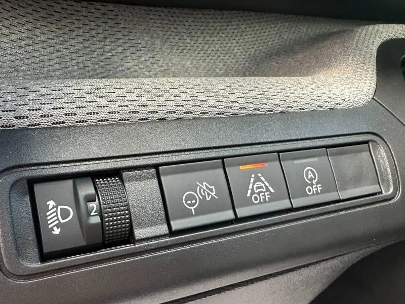 Gros plan sur les commandes noires du tableau de bord de la Citroën C3 1.2 Turbo 100ch MAX, tissu gris clair visible.