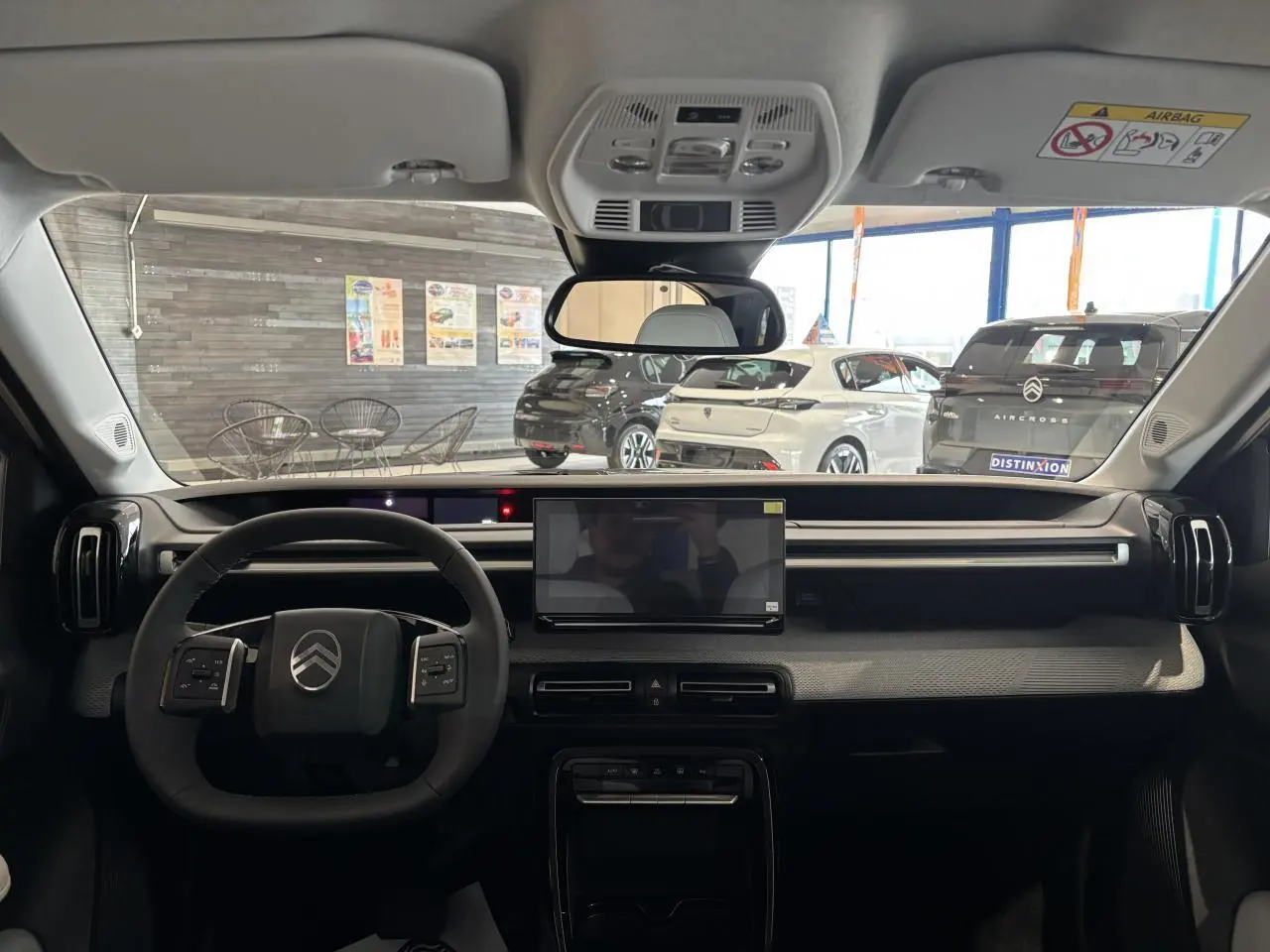 Vue intérieure avant du tableau de bord noir et gris avec écran tactile central et volant multifonctions Citroën C3 Aircross 2026.