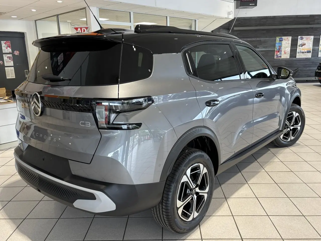 Vue 3/4 arrière droite du Citroën C3 Aircross 2026 gris métallisé avec toit noir et jantes alliage diamantées.