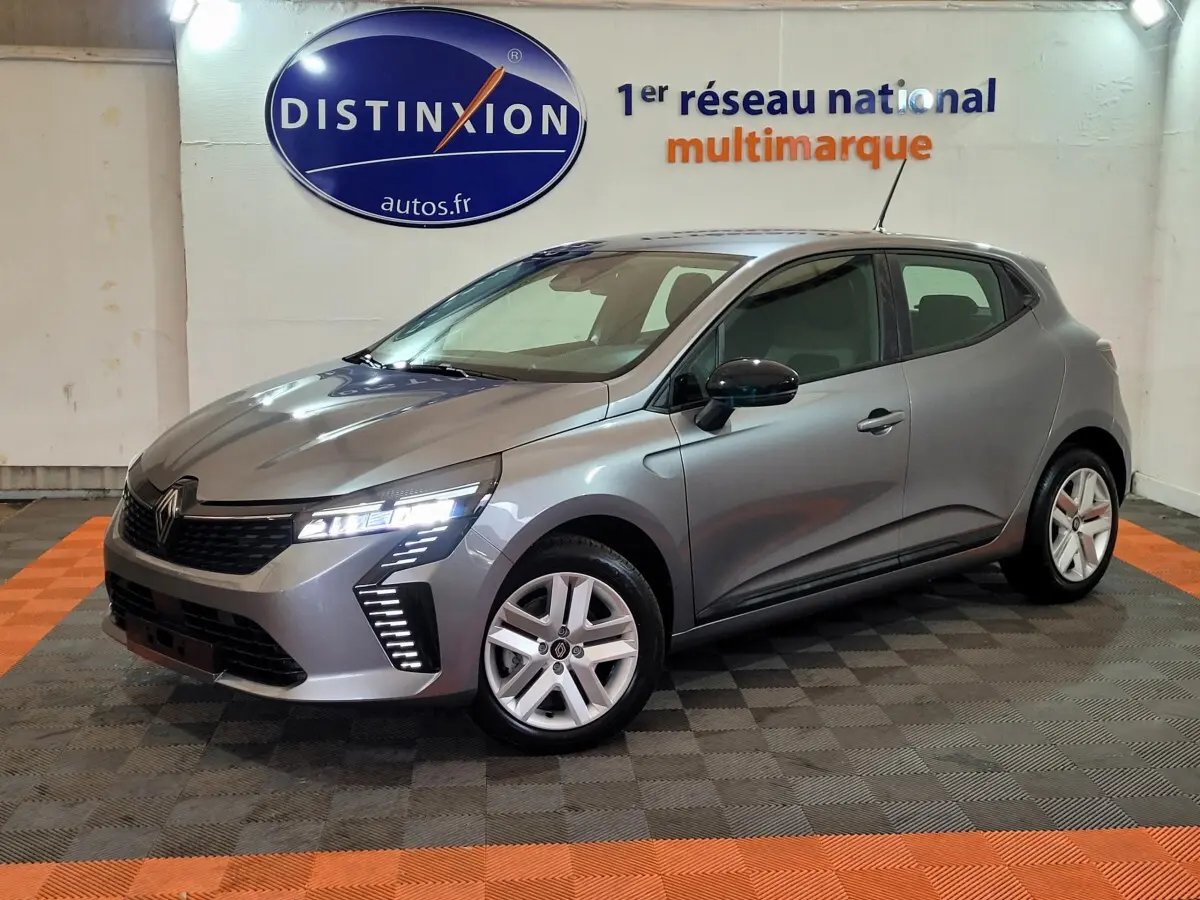 Renault Clio Evolution Blue dCi 100 2025 gris foncé vue 3/4 avant avec feux LED allumés dans un showroom