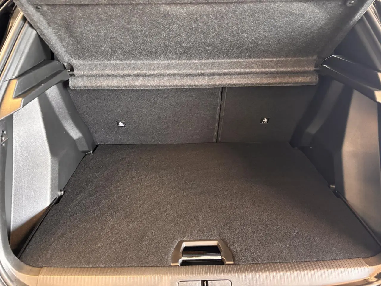 Coffre ouvert du Peugeot 2008 gris 2025, montrant l'espace de rangement et la couverture de coffre relevée.
