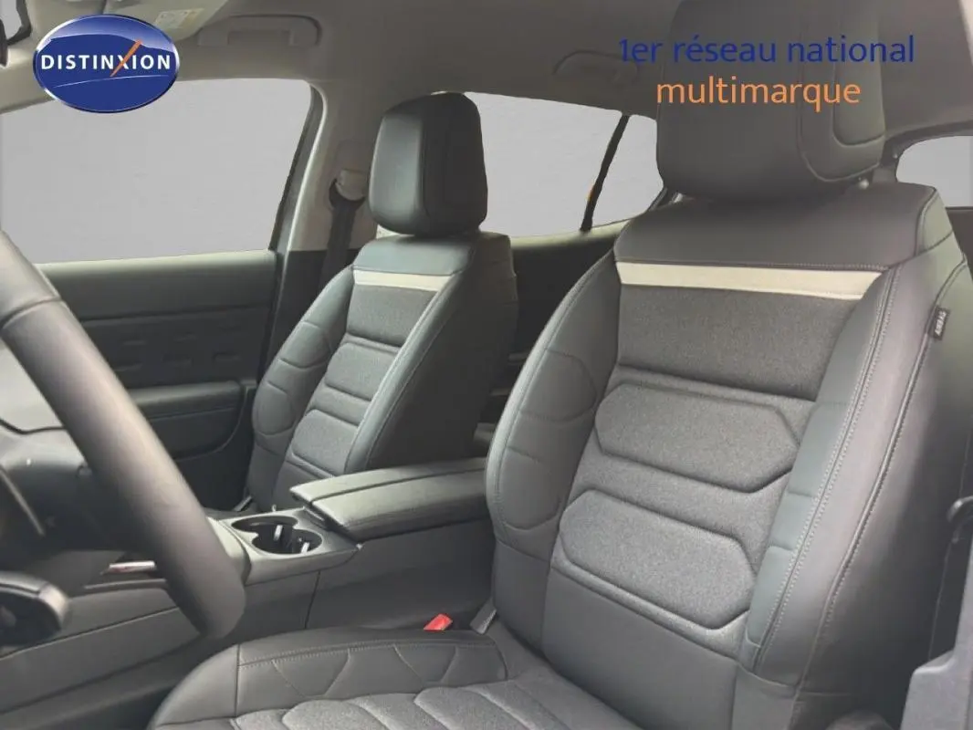 Vue intérieure côté conducteur du Citroën C5 Aircross 2025, sièges en cuir et tissu gris avec accoudoir central.