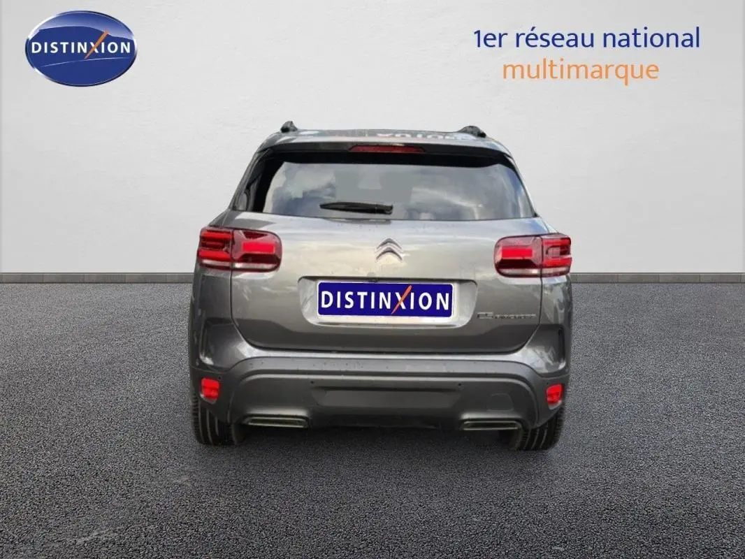 Vue arrière d'un Citroën C5 Aircross platine 2025 avec barres de toit et feux rouges distinctifs.