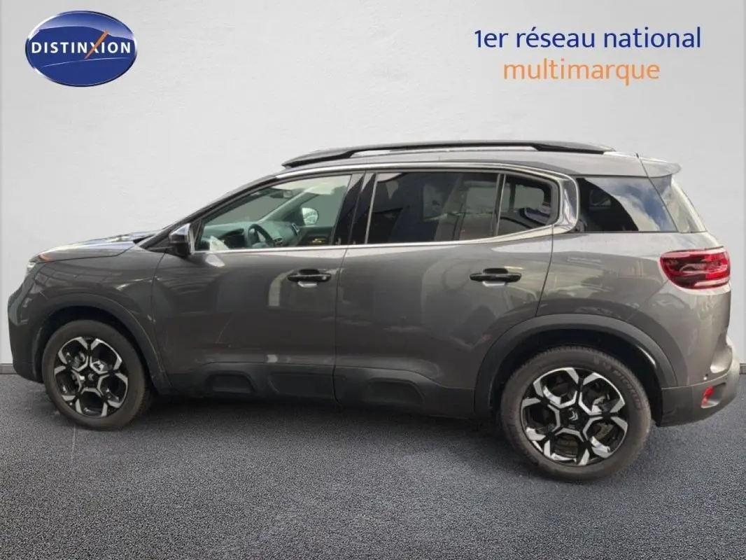 Vue latérale droite d'un Citroën C5 Aircross platine 2025 avec barres de toit et jantes aluminium distinctives.