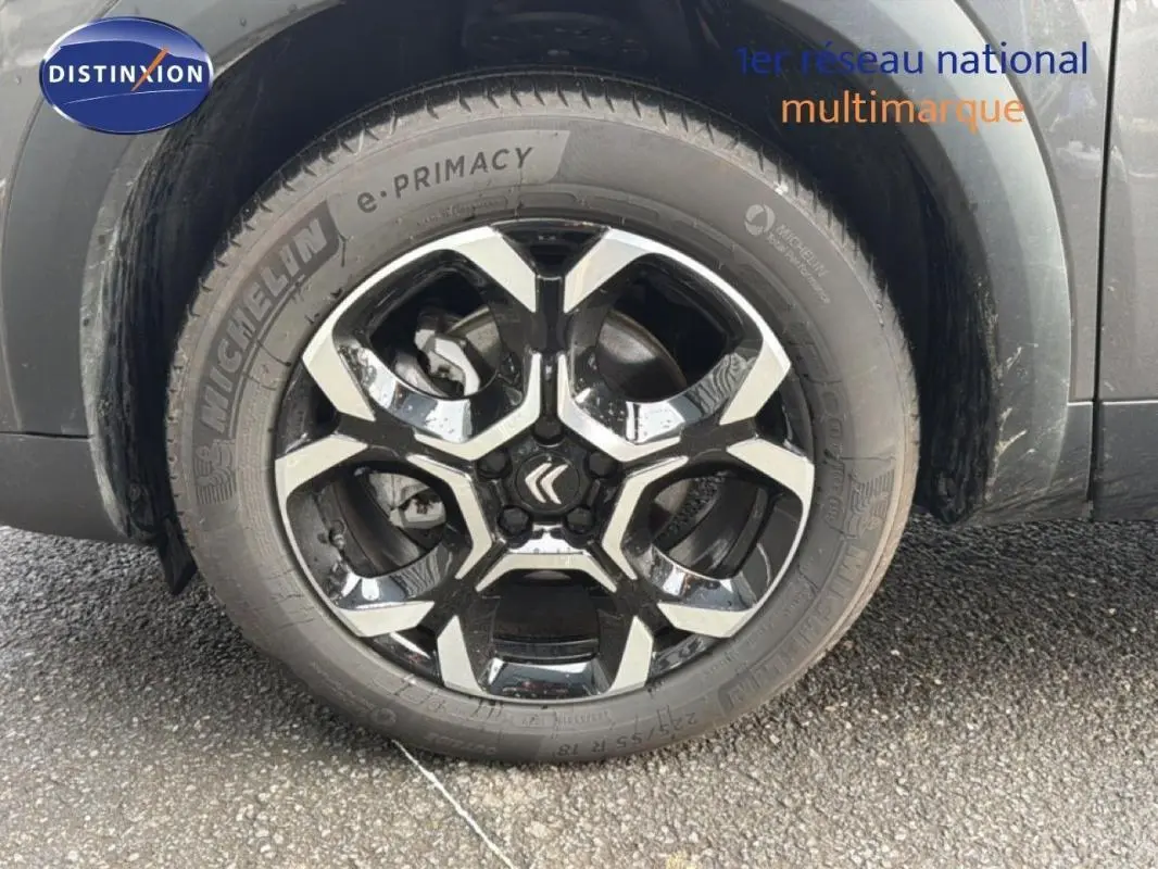 Gros plan sur la jante aluminium noire et argentée du côté gauche d'un Citroën C5 Aircross platine 2025.