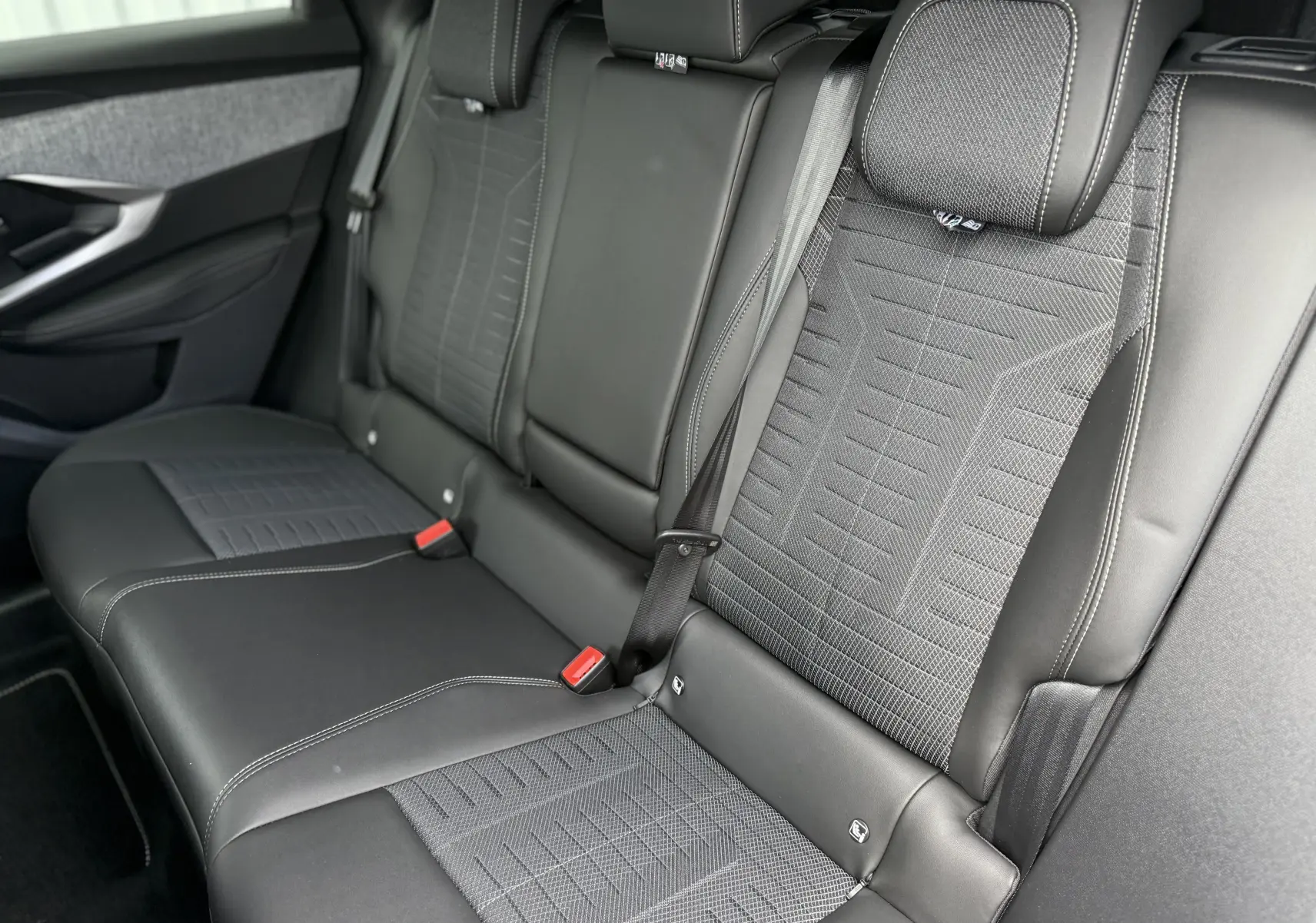 Vue intérieure des sièges arrière en cuir noir et tissu gris du Peugeot 3008 Hybrid 2026, côté droit visible.