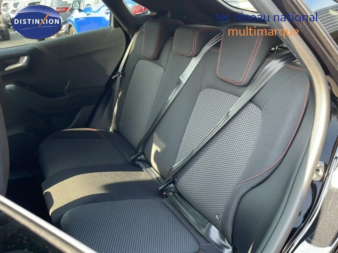 Vue latérale des sièges arrière en tissu noir avec surpiqûres rouges du Ford Puma noir Agate Metal 2023.