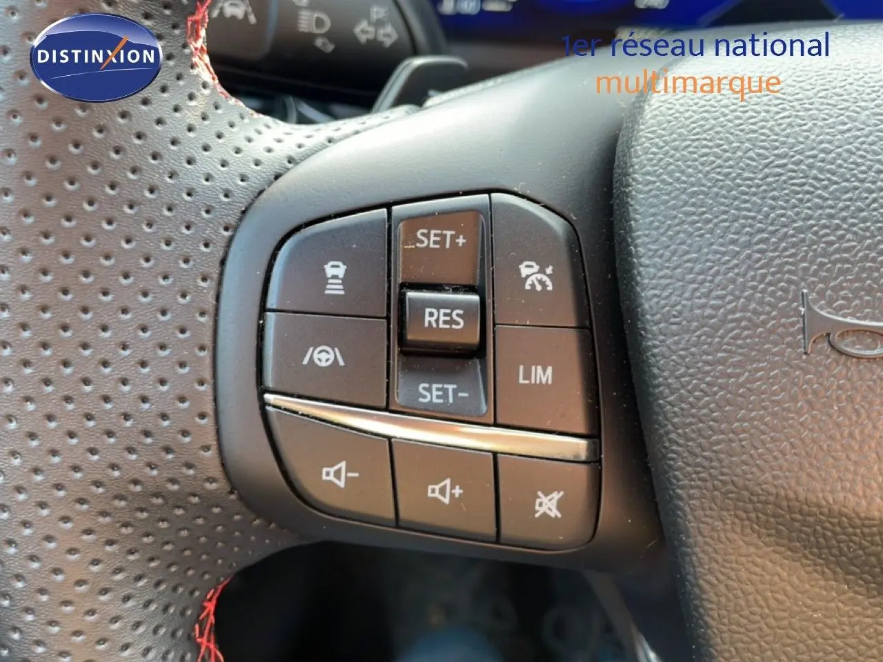 Gros plan sur les commandes de régulateur et volume au volant perforé noir du Ford Puma 2023 finition ST-Line.