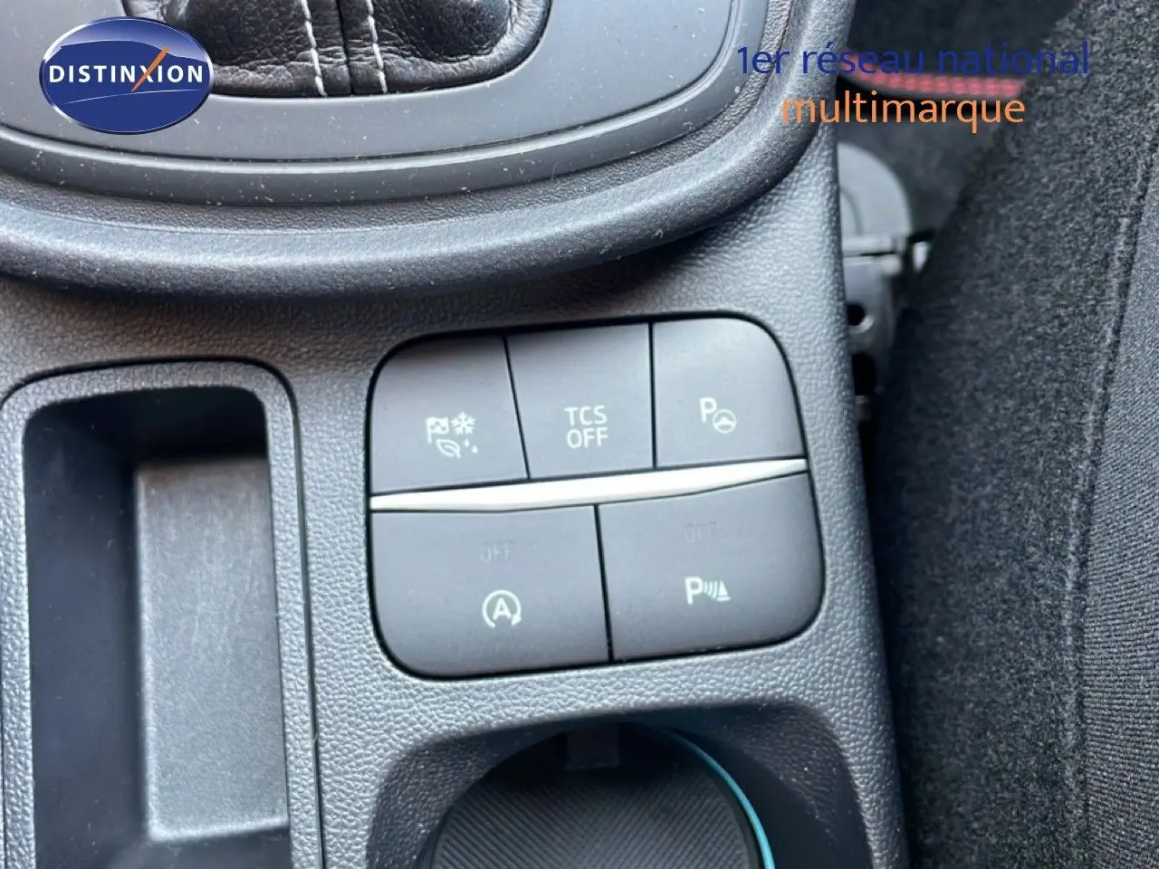 Gros plan sur les commandes noires du tableau de bord du Ford Puma 2023, avec boutons de sécurité et assistances visibles.