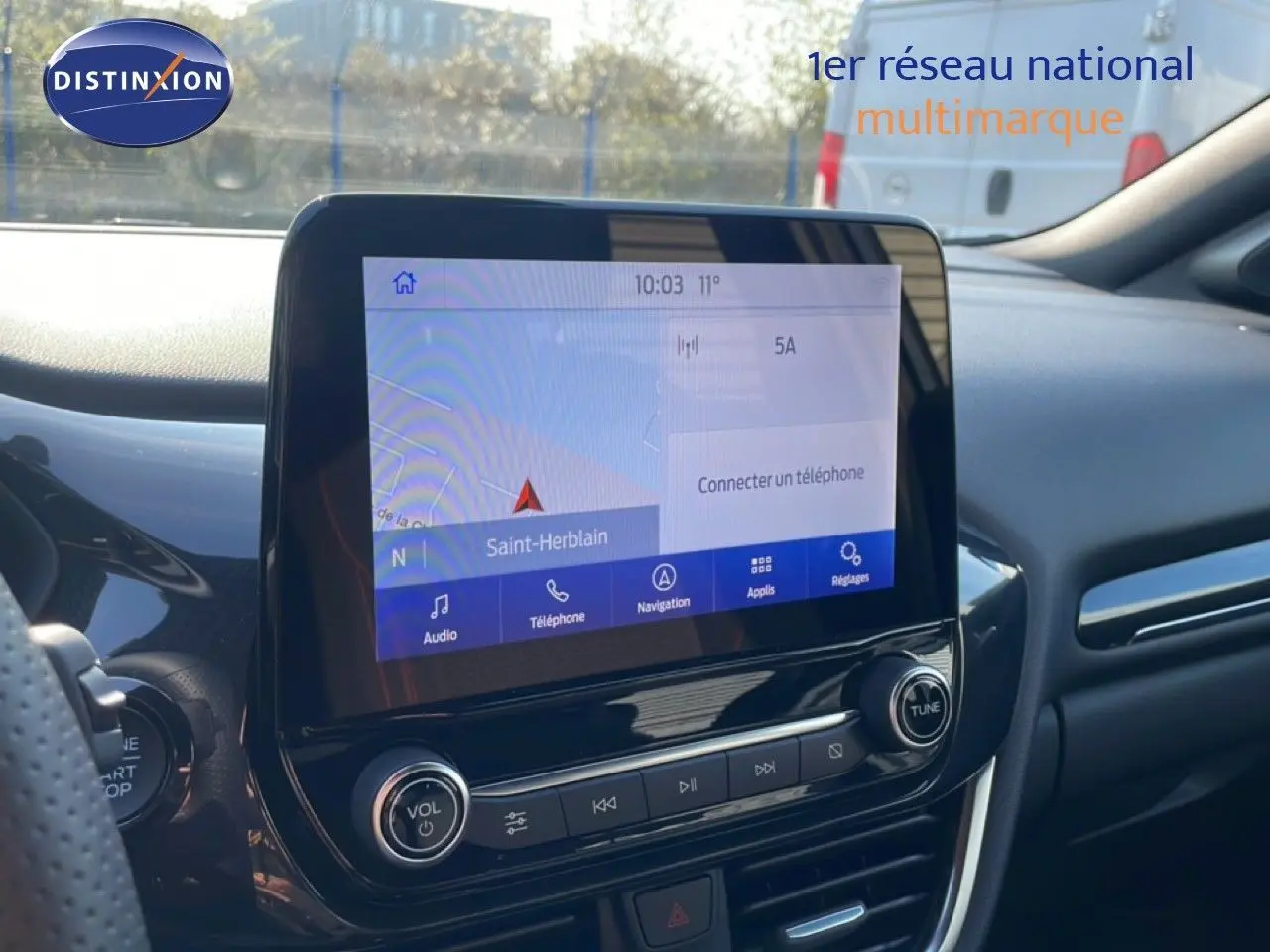 Vue intérieure centrée sur l'écran tactile du tableau de bord du Ford Puma noir agate métal, avec navigation affichée.