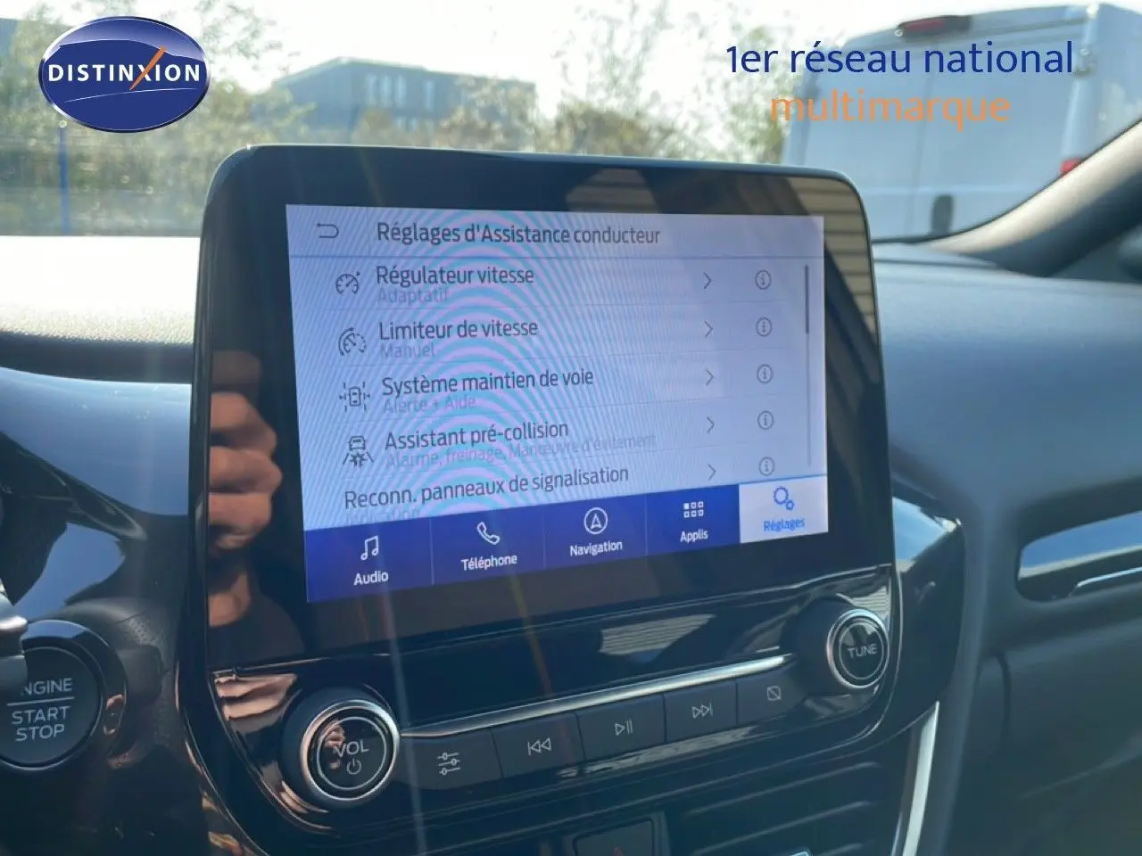 Vue intérieure centrée sur l'écran tactile multimédia du Ford Puma noir agate, affichant les réglages d'assistance conducteur.