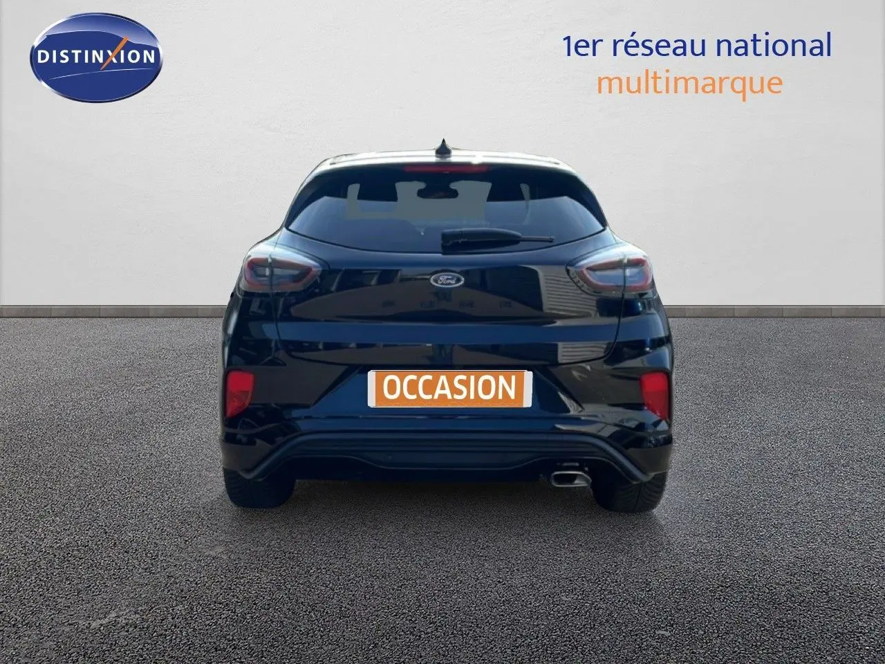 Vue arrière d'une Ford Puma noire Agate Métal 2023 avec feux LED et sortie d'échappement visible sur sol bitumé.