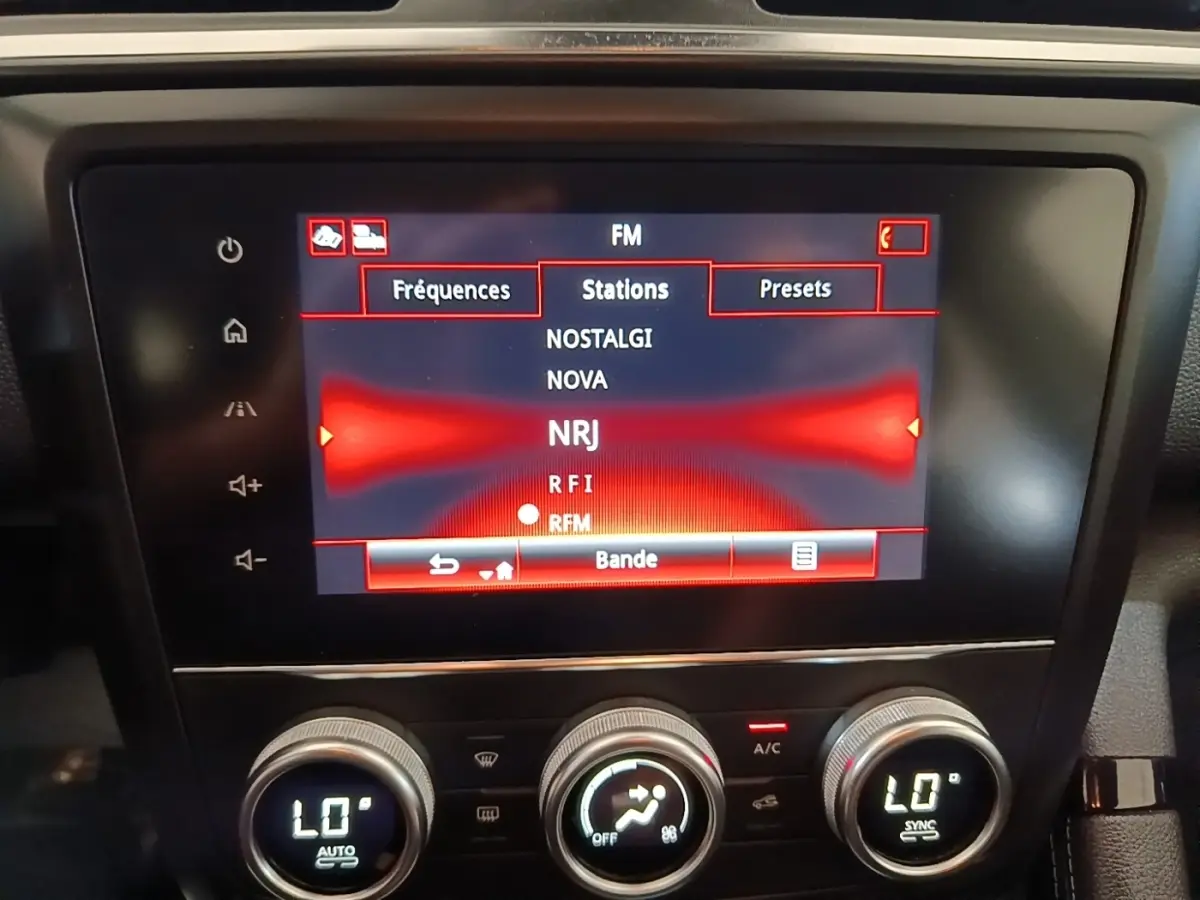 Écran tactile central du tableau de bord du Renault Kadjar gris foncé, affichant les stations radio FM.