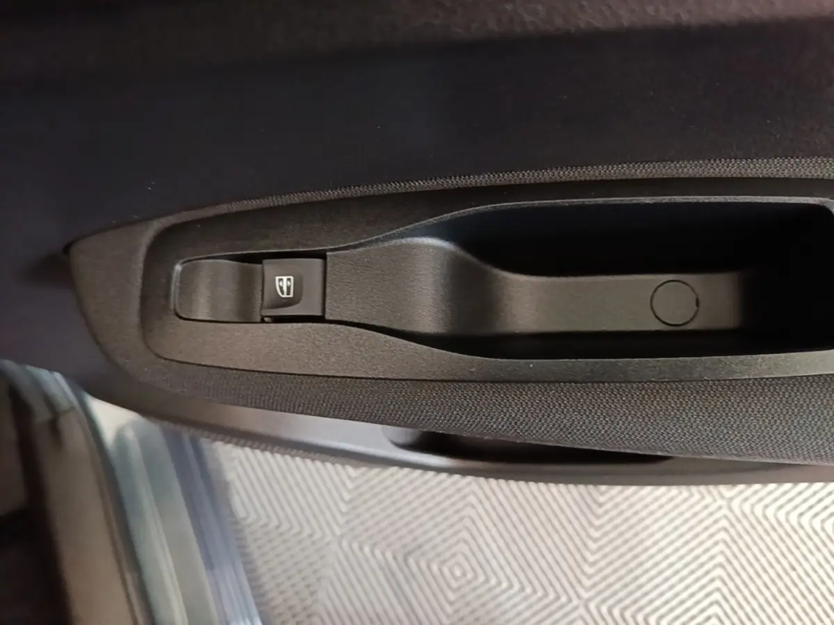 Gros plan sur la commande de lève-vitre côté conducteur du Renault Kadjar gris foncé, intérieur tissu noir.