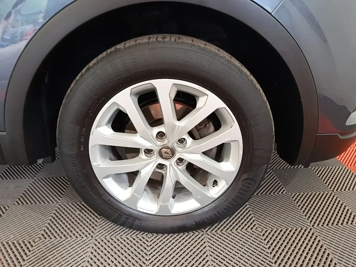 Gros plan sur la roue avant gauche avec jante alliage argentée du Renault Kadjar gris foncé 2021.