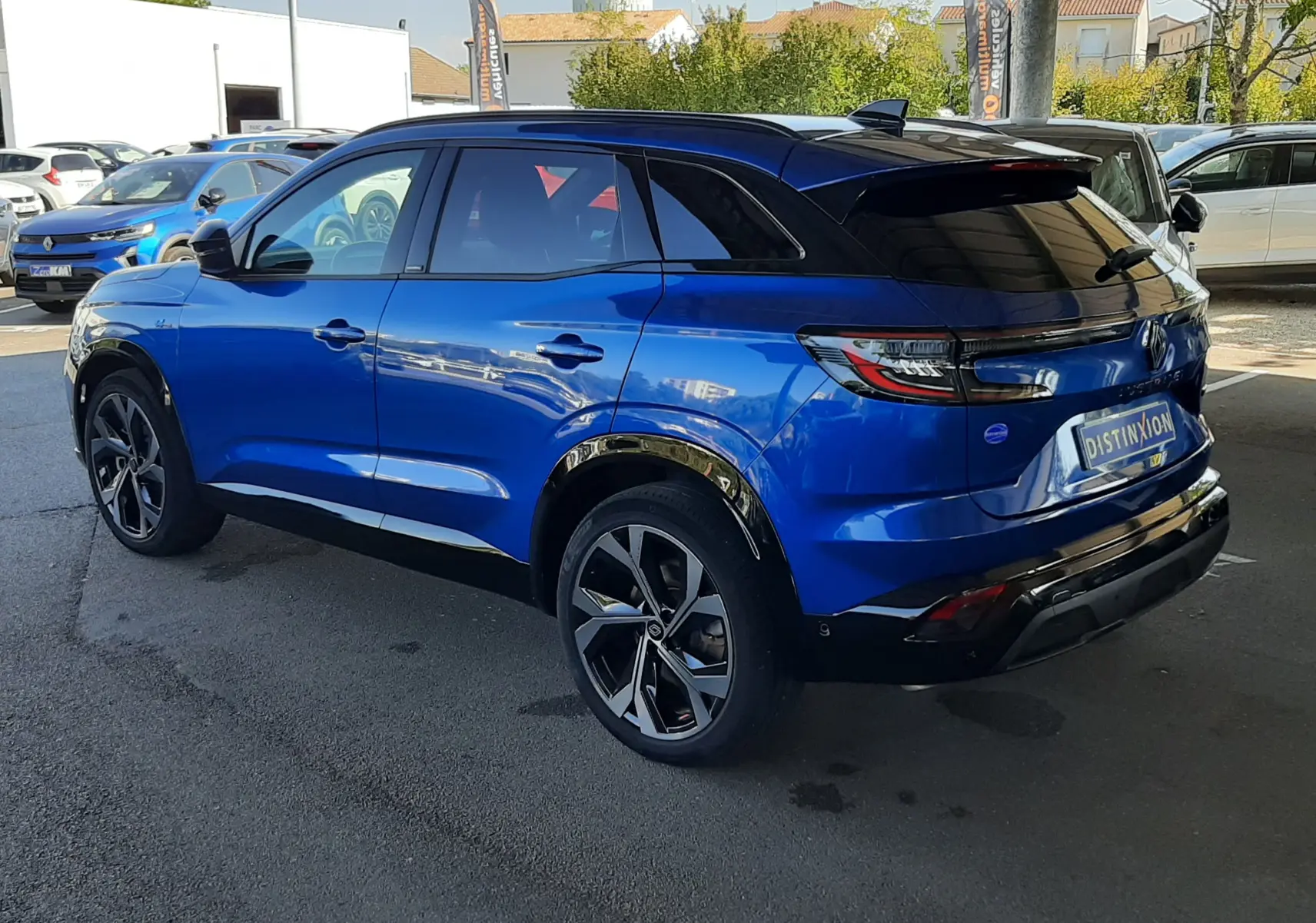 Renault Austral E-Tech 200 bleu Iron en 3/4 arrière droit, toit noir et jantes alliage distinctives.