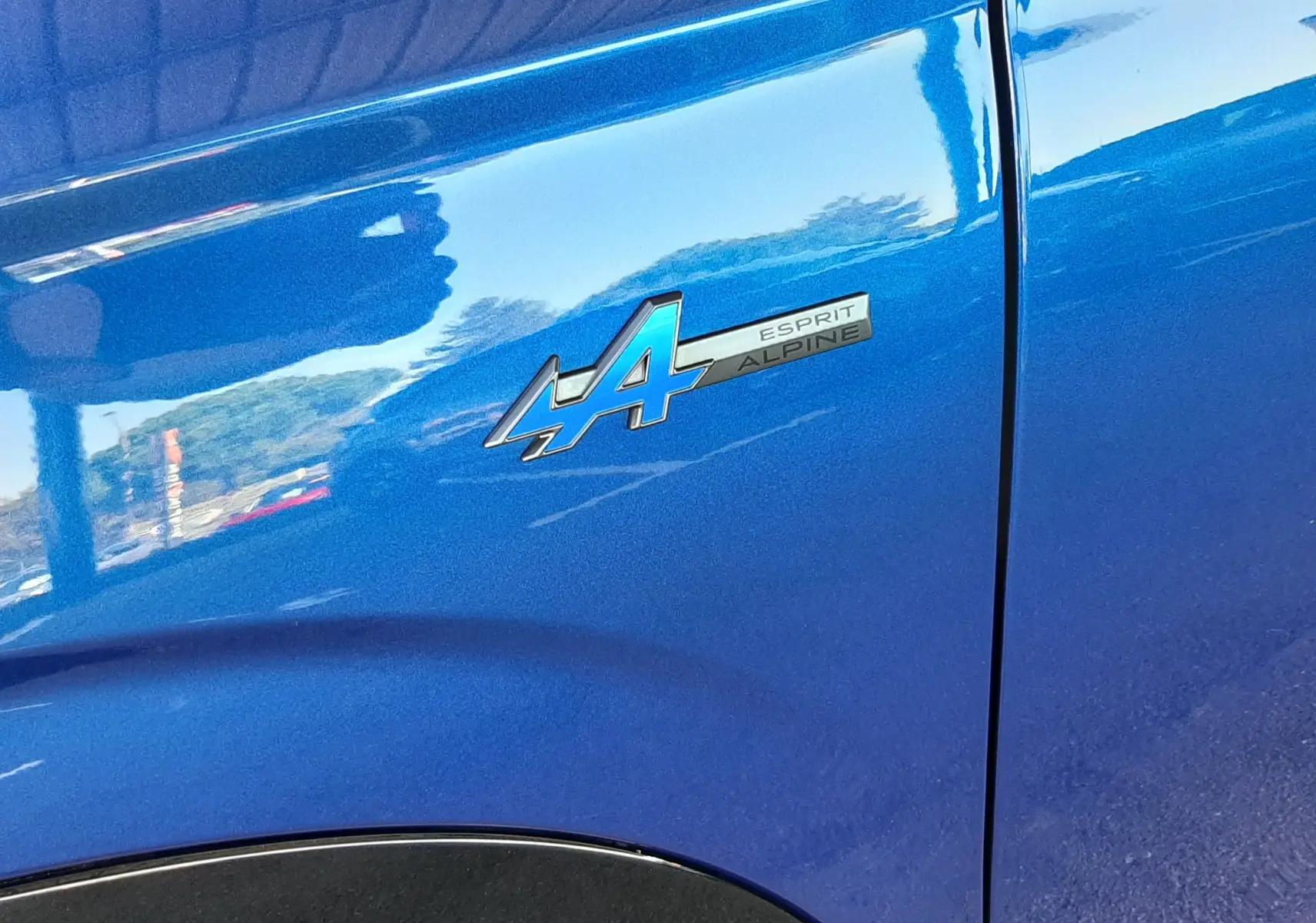 Détail de l'aile avant droite bleu iron du Renault Austral E-Tech 200 Esprit Alpine avec logo Esprit Alpine.