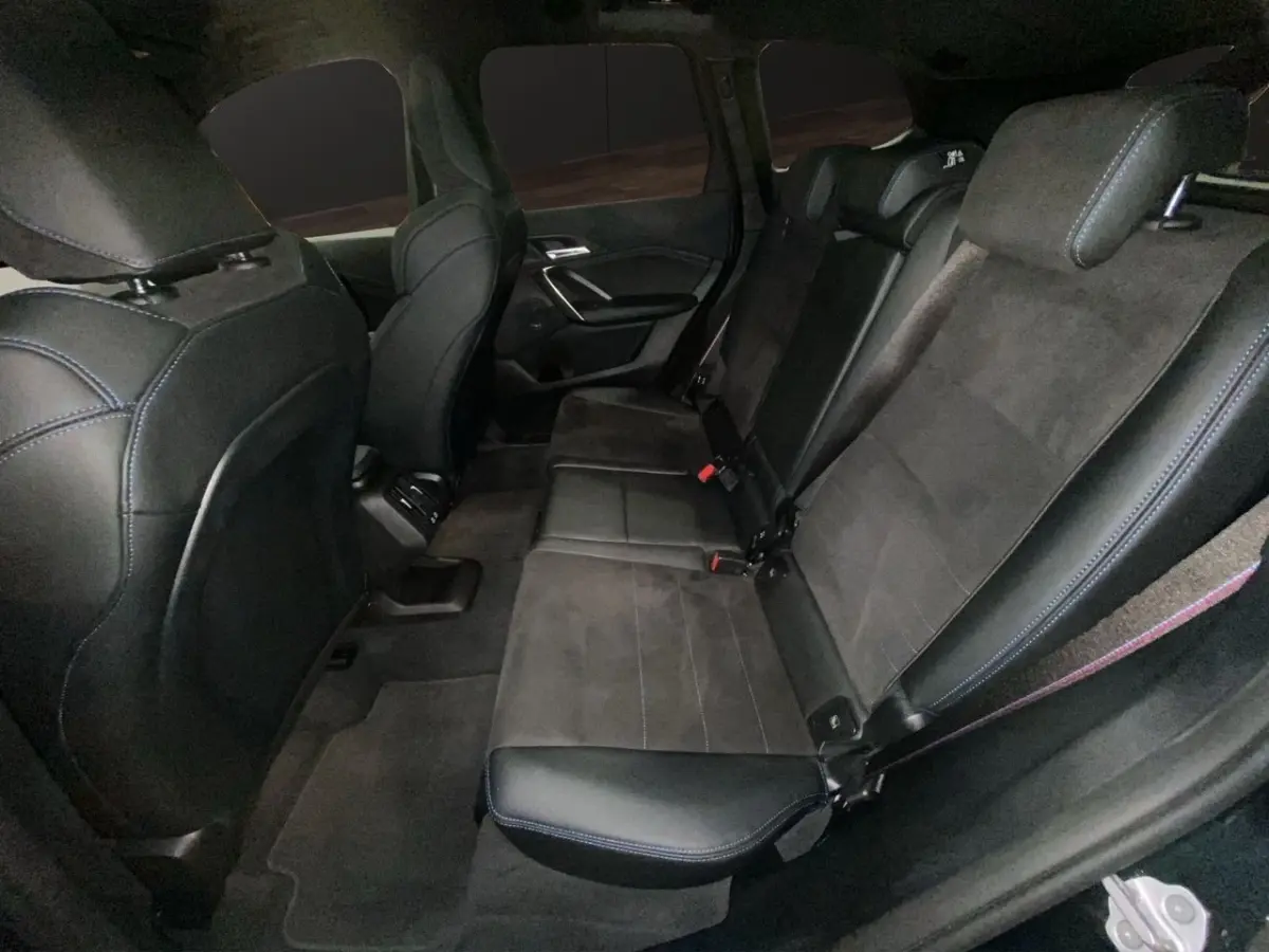 Vue intérieure côté droit des sièges arrière noirs en cuir et alcantara du BMW X1 xDrive20d M Sport PRO 2025.