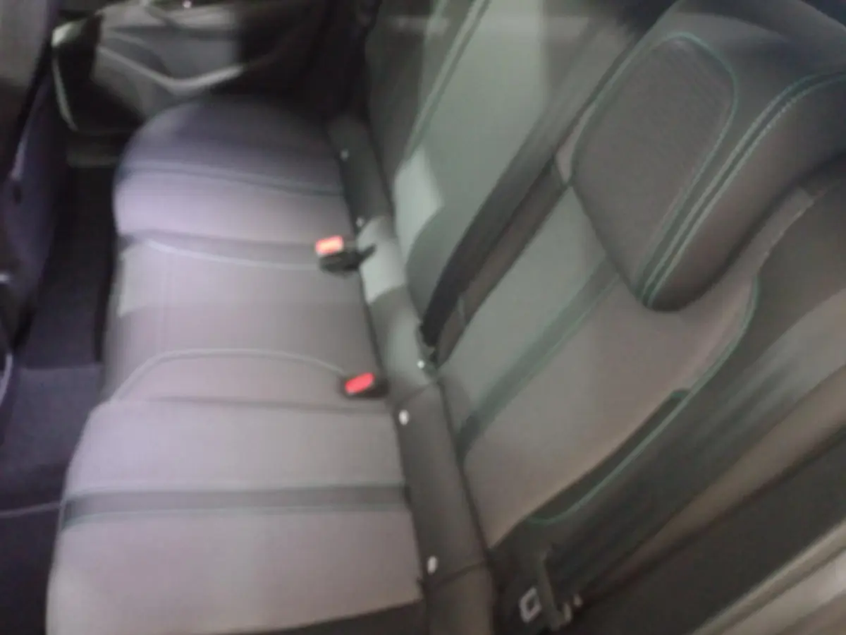 Vue rapprochée de la banquette arrière grise de la Peugeot 308 PHEV 180 E-EAT8 Allure avec ceintures et appuie-tête.