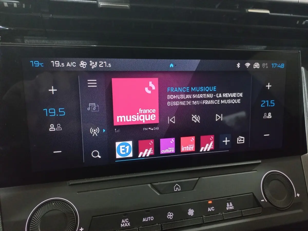 Écran tactile central de la Peugeot 308 PHEV 180 Allure 2025 affichant la radio et la climatisation.
