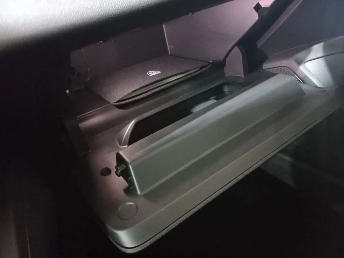 Vue rapprochée de la boîte à gants ouverte du Peugeot 308 PHEV 180 E-EAT8 Allure, intérieur noir.