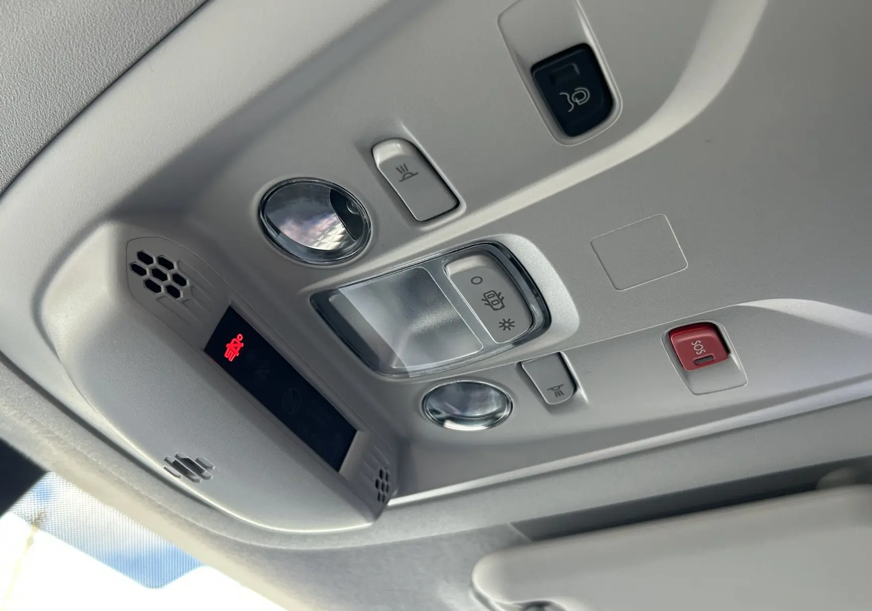 Plafonnier intérieur du Peugeot Partner Fourgon blanc 2025 avec commandes d'éclairage et bouton SOS rouge visible.