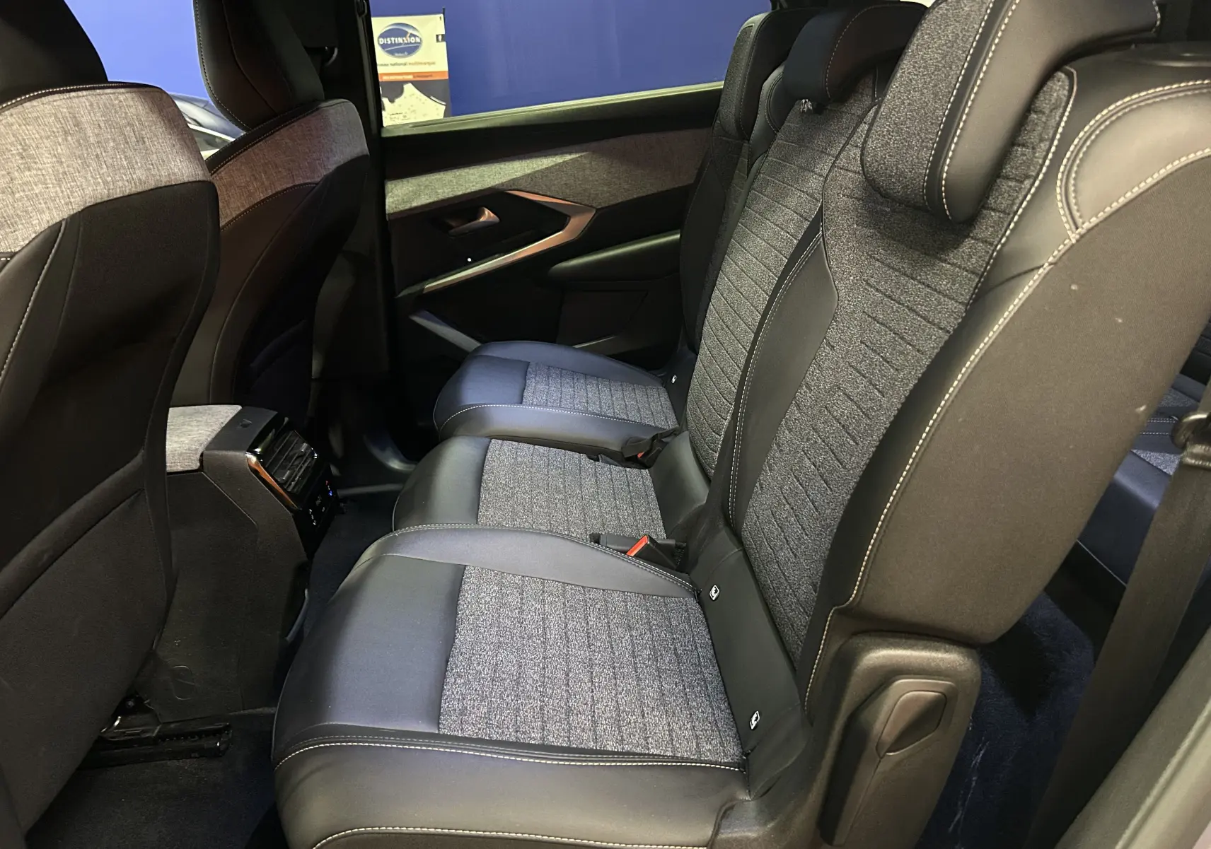 Vue intérieure côté droit des sièges arrière en tissu et cuir gris du Peugeot 5008 III Hybrid 145 e-DCS6 Allure 2025.