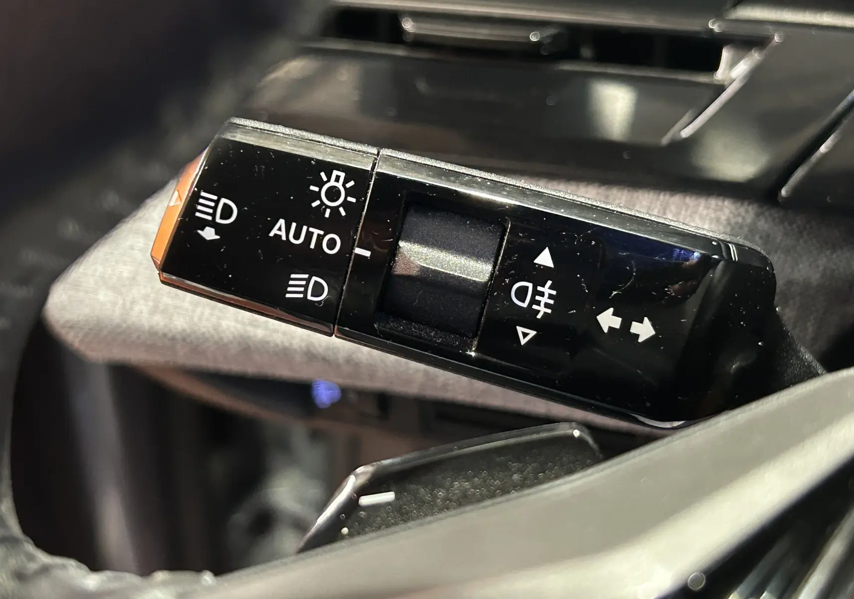 Gros plan sur la commande des feux automatiques et antibrouillard du Peugeot 5008 III Hybrid 145 e-DCS6 Allure.