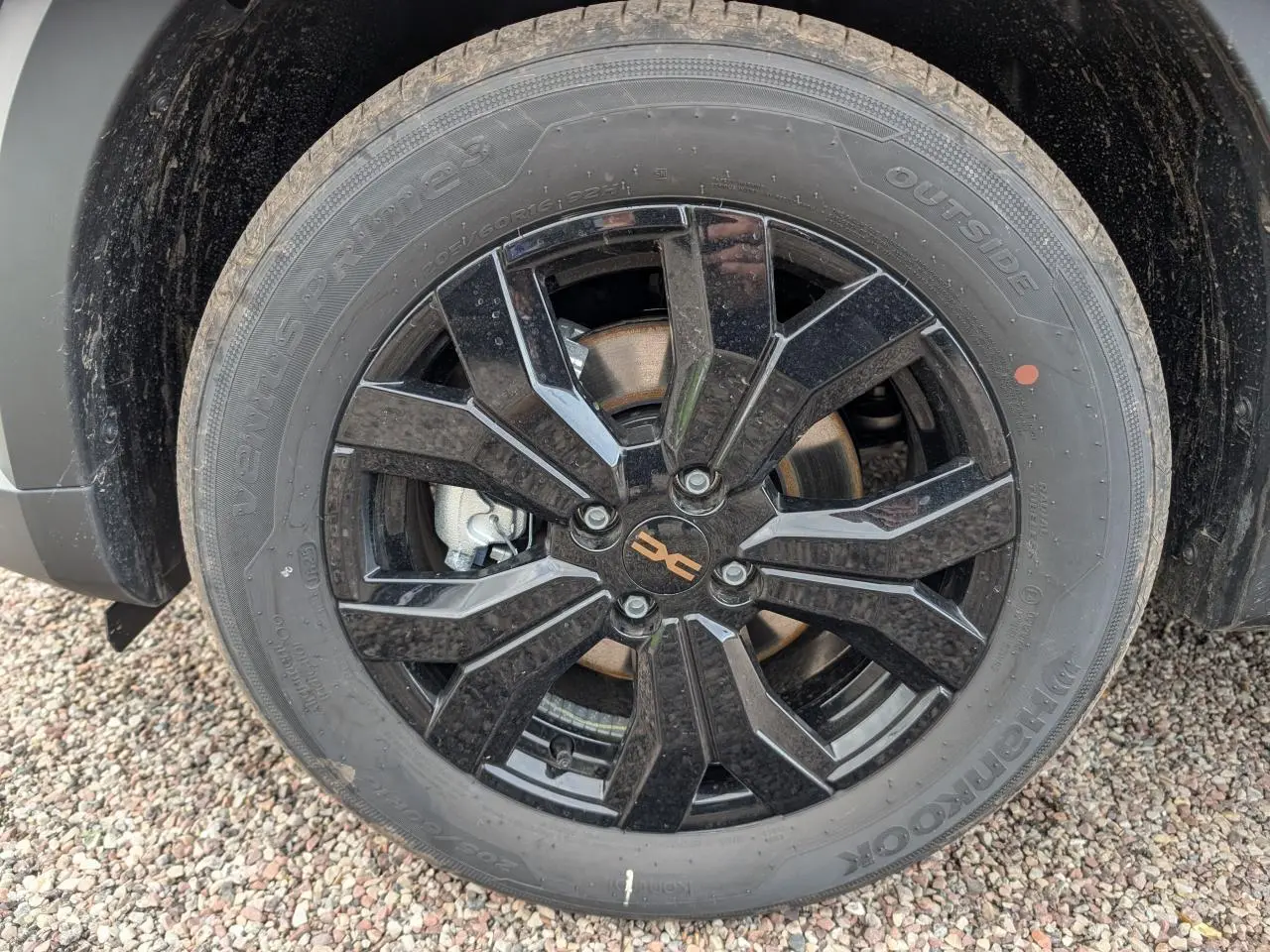 Gros plan sur la jante aluminium noire 16 pouces Mahalia du Dacia Jogger vert métallisé 2025, avec logo brun cuivré.