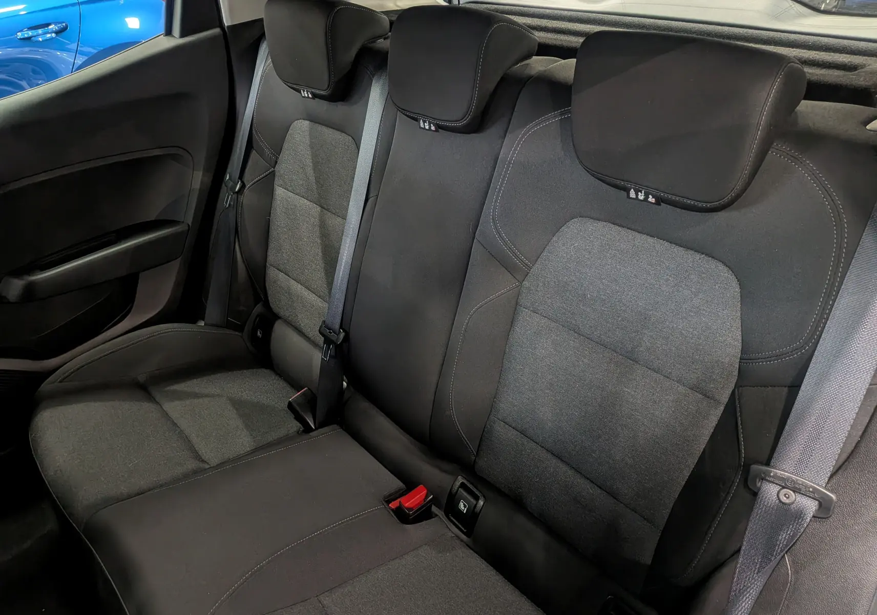 Vue intérieure des sièges arrière en tissu gris foncé de la Renault Clio V TCe 90 CH AUTO-ECOLE, sans visibilité extérieure.