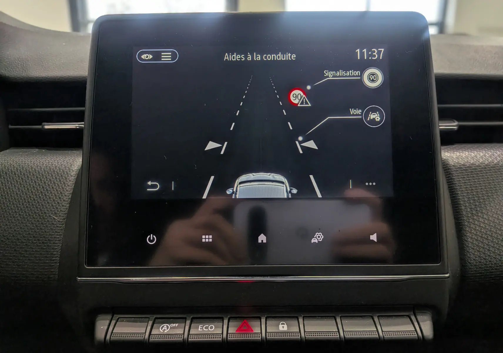 Écran central de la Renault Clio V TCe 90 Auto-école montrant les aides à la conduite avec affichage de la signalisation et voie.